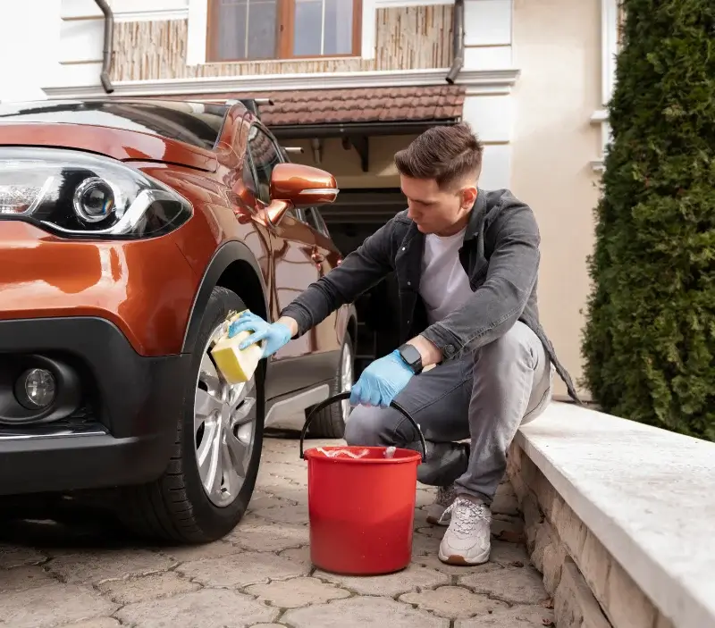 Lavage auto à domicile Andrézieux-Bouthéon : professionnel intervenant sur un véhicule